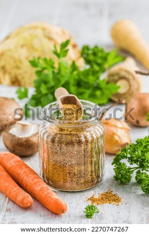 Homemade vegetable broth powder, organic vegetable stock, with raw vegetables on white wooden background, vertical
