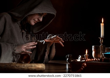 Medieval witch conjures with hands - product freedom Royalty-Free Stock Photo #2270751861