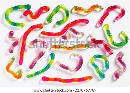 Colorful gummy jelly worm candies on white background, top view