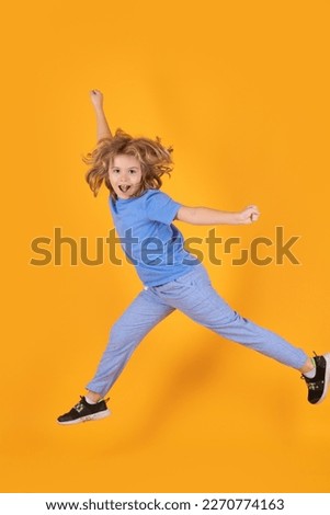 Funny boy jumping. Little child jumping over a yellow background.