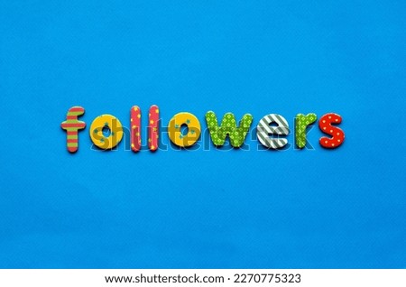 word followers from bright colored paper letters on blue paper background