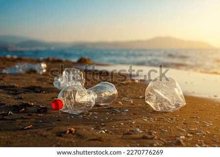 Plastic bottles on the sandy beach. Environmental pollution. Royalty-Free Stock Photo #2270776269