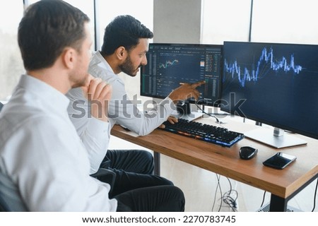 Two diverse crypto traders brokers stock exchange market investors discussing trading charts research reports growth using pc computer looking at screen analyzing invest strategy, financial risks Royalty-Free Stock Photo #2270783745