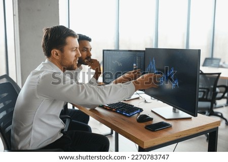 Two diverse crypto traders brokers stock exchange market investors discussing trading charts research reports growth using pc computer looking at screen analyzing invest strategy, financial risks Royalty-Free Stock Photo #2270783747