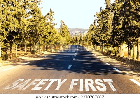 Safety first, message on the road around pine trees. Concept of safe driving and preventing traffic accident