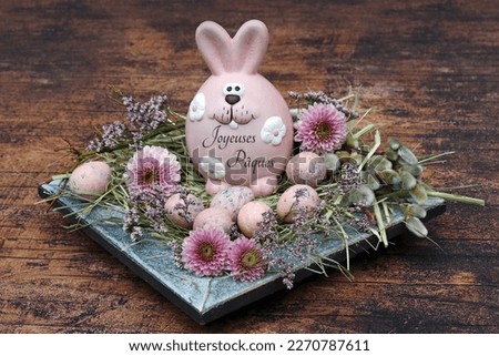 Happy Easter: Lettered Easter bunny with quail eggs and flowers in an Easter nest. French inscription means Happy Easter.