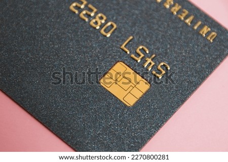 Bank card with chip macro on pink background. Modern technologies of payment for goods in the store and online.