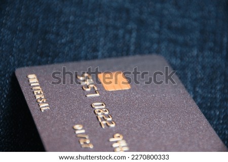 Bank card with a modern chip on a denim background. Concept of safe online operations with bank accounts and protection of bank cards from fraudsters.