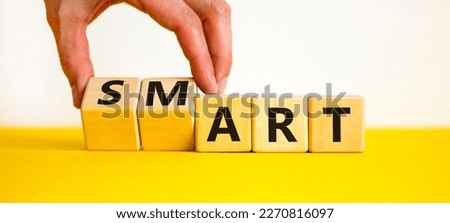 Smart art symbol. Businessman turns cubes and changes the word 'smart' to 'art'. Beautiful yellow table, white background. Business and smart art concept, copy space.