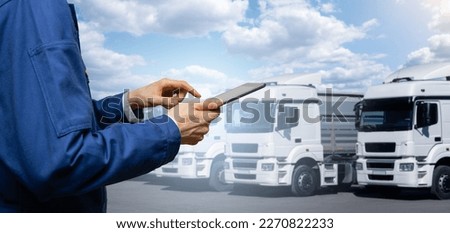 Manager with a digital tablet next to trucks. Fleet management Royalty-Free Stock Photo #2270822233