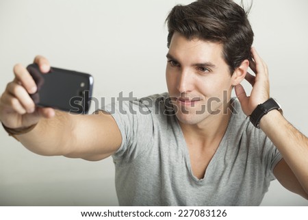 young attractive man taking pictures of him self with phone-selfiy