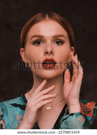 Beautiful young redhead woman i colourful blouse