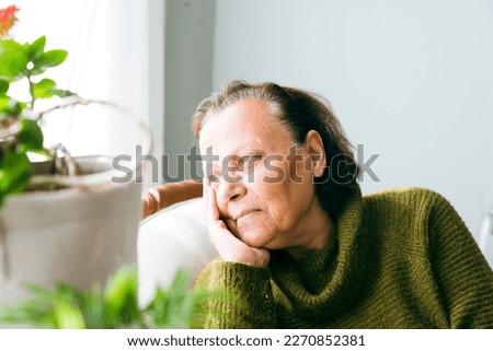 Shot of a senior woman sitting alone in her living room