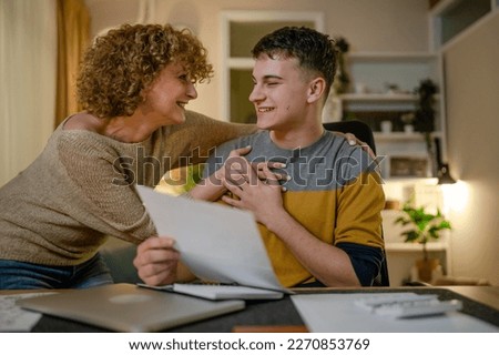 mature woman and son caucasian man teenager receive letter read good news student get scholarship or invitational letter from university share good news and excitement with his mother real people Royalty-Free Stock Photo #2270853769