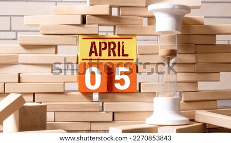 April calendar background with number 5. Stationery pens and pencils in a case on a wooden vintage background. Copy space notepad with pencils and calendar. Planner place for text.