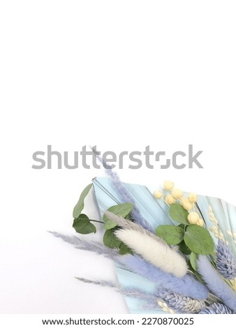 Spring card. Topper on the cake. Blue leaves of Palma and dry flowers. Flat lay. Top view. White background. High quality photo