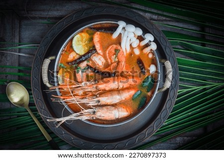 Tom Yum Goong Thai hot spicy soup shrimp with lemon grass,lemon,galangal and chilli on  top view on dark backgroundThailand Food Royalty-Free Stock Photo #2270897373