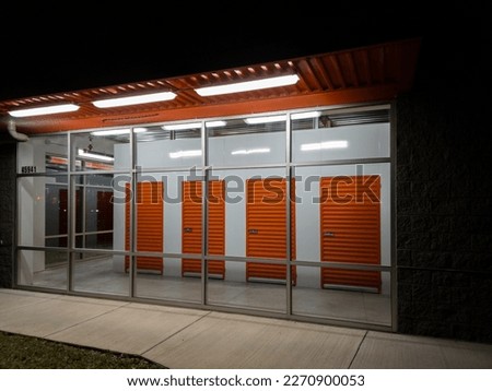 Night view  of orange metal doors at an air-conditioned self storage facility