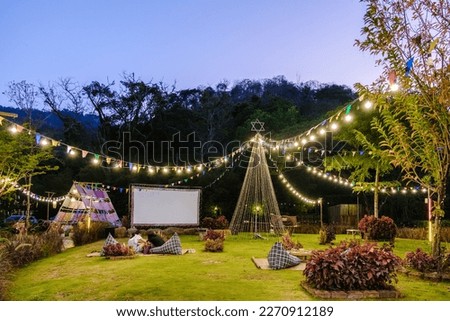 outdoor cinema film in a tropical garden with Christmas lights. H Royalty-Free Stock Photo #2270912189