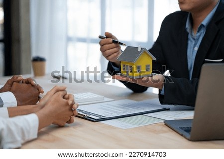 Young Asian home sales agents, insurance agents, and real estate agents offer young Asian entrepreneurs information on price conditions when signing a contract to buy rent house in the office.