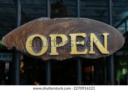 Golden OPEN sign on wooden background