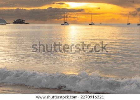 Late day lights at sunset on Naiyang Beach in the northwest of the island of Phuket in Thailand.