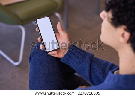 Young businessman holding a mobile phone with empty blank white screen with free advertising space for inserting mobile application or graphic design. Mockup. People and modern wireless technology
