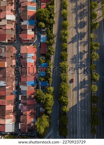 Drone shot looking down on a downtown driveway with red car in the morning.