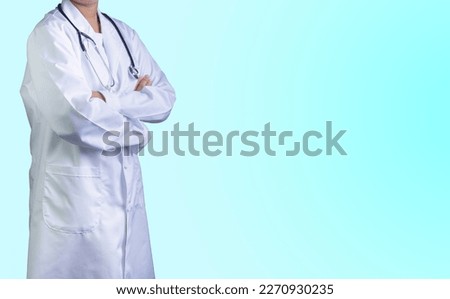 Doctor in lab coat with arms crossed against light green background