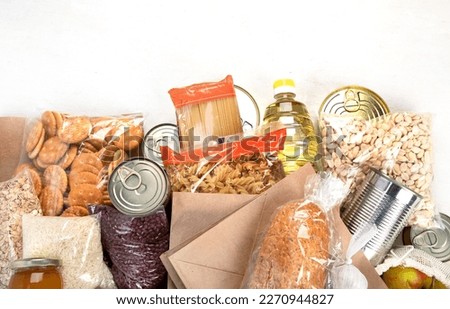 Food donations with pasta, rice, oil, peanut butter, canned food, jam and other  on light background, top view with copy space. Food donations or delivery concept. Royalty-Free Stock Photo #2270944827