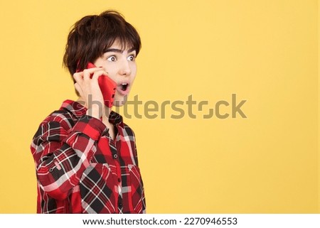 Surprised androgynous person talking to the mobile