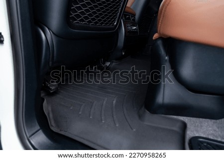 Clean car floor mats of black rubber under rear passenger seat in the workshop for the detailing vehicle dry cleaning. Auto service industry. Interior of sedan. Royalty-Free Stock Photo #2270958265