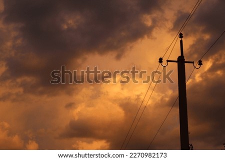 power pole on the background of yellow clouds, optical illusion yellow sky, atmospheric photo power wire