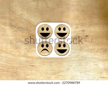 Happy and sad emoji isolated on wooden background