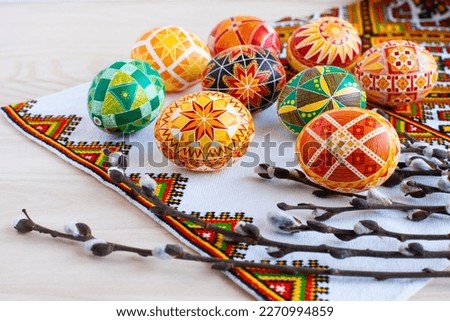 colorful traditional Ukrainian Easter eggs and willow twigs on the background of an embroidered towel and a wooden table Royalty-Free Stock Photo #2270994859