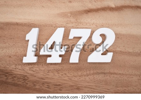 White number 1472 on a brown and light brown wooden background.