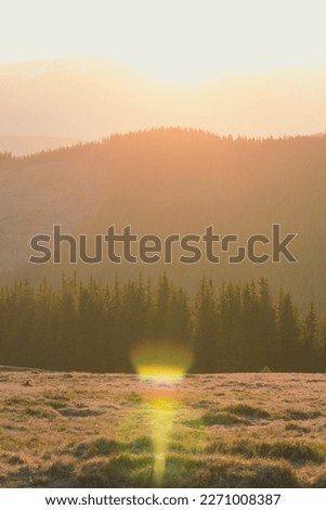 Sun glowing behind mountains silhouette landscape photo. Nature scenery photography with sunny mist on background. Ambient rim light. High quality picture for wallpaper, travel blog, magazine, article