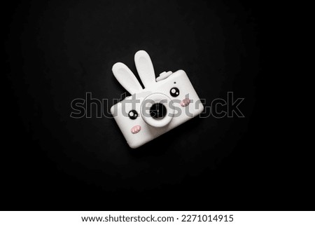 
funny children's toy camera in the shape of an easter bunny isolated on a black background.