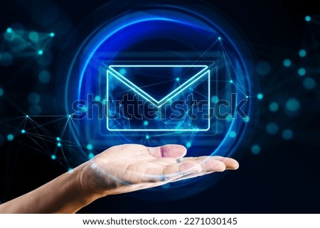 Mail, email and network communication concept with digital glowing envelope symbol in abstract sphere above human hand palm on abstract dark background with blurred dots