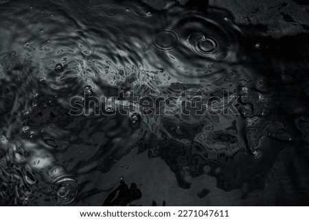 Crumpled textured dark fabric lies in the water. Abstract image with beautiful highlights for your creative design or stylish illustrations.