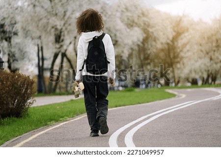 Young african american woman riding on the skateboard on the road in the park	
                              