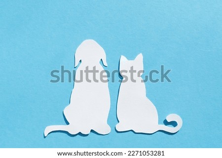 Paper silhouettes of pets. Cat and dog on blue background.