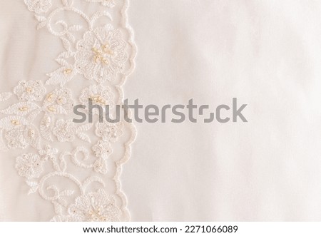beige satin fabric with lace border and bisser embroidery. wedding background. Template for invitations, books, postcards, greetings. space for text