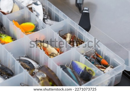 Fishing tackles and fishing baits in box .Classic Colored Fishing Lure , Beautiful Background digital image.Fishing on the lake at sunset.  Royalty-Free Stock Photo #2271073725