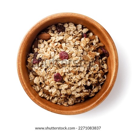 Granola with nuts and raisins in a wooden plate close-up on a white background. Top view Royalty-Free Stock Photo #2271083837