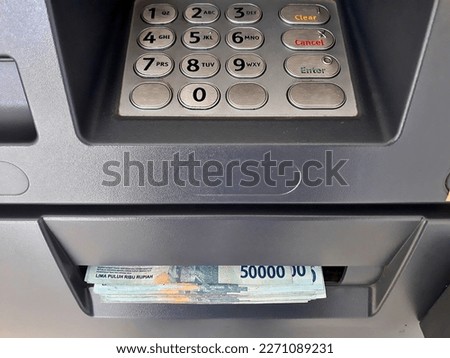 Close up the atm machine number buttons for money withdraw with indonesian money rupiah