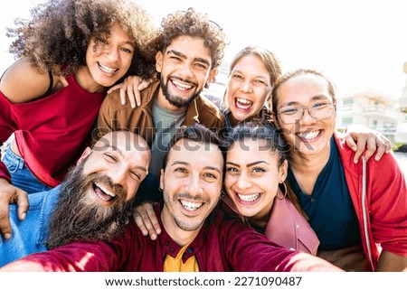 Multi cultural guys and girls taking genuine selfie outside - Happy diversity life style concept on young multiracial best friends having fun day together at summer location - Warm backlight filter Royalty-Free Stock Photo #2271090487