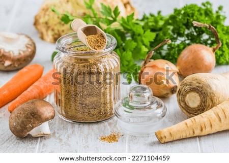 Homemade vegetable broth powder, organic vegetable stock, with raw vegetables on white wooden background
