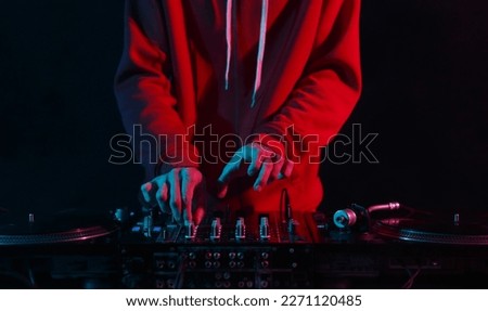 Hands of DJ mixing vinyl records with sound mixer in close up. Professinal club disc jokey plays set on party Royalty-Free Stock Photo #2271120485