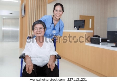 Asian doctor or nurse caring for an adult female patient sitting in a hospital recuperating from an injury. rehabilitation of elderly patients Young woman smiling at the old woman